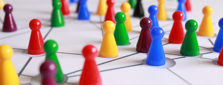 Kontaktpersonen Fotografie in Nahaufnahme von gelbgrünen, roten und braunen Plastikkonen auf weißer, linierter Oberfläche